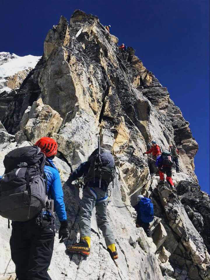 On a steep rocky spot of Mt Ama Dablam Climbing