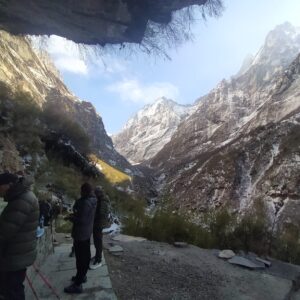Trekkers on the Annapurna Base Camp trail with snowy mountains ahead.