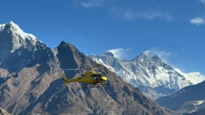 helicopter flying from Gorakshep to Lukla with Mount Everest and neighboring Himalayan peaks in the background under a clear blue sky.”