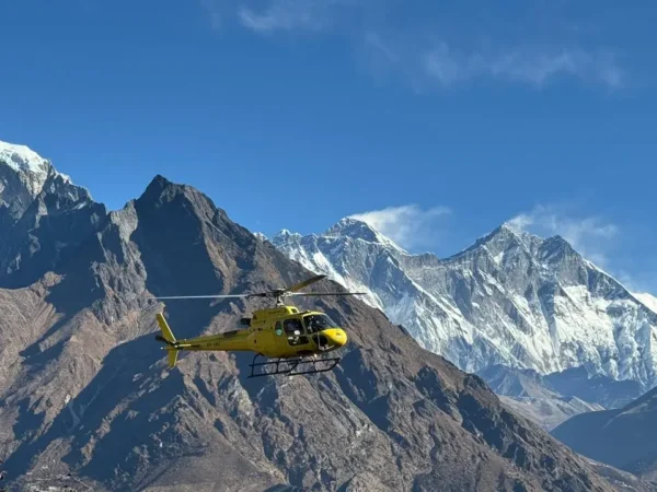helicopter flying from Gorakshep to Lukla with Mount Everest and neighboring Himalayan peaks in the background under a clear blue sky.”