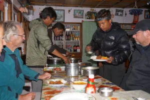 Trekkers enjoying dinner at a traditional teahouse in Ghorepani, Nepal during the Annapurna trekking route.