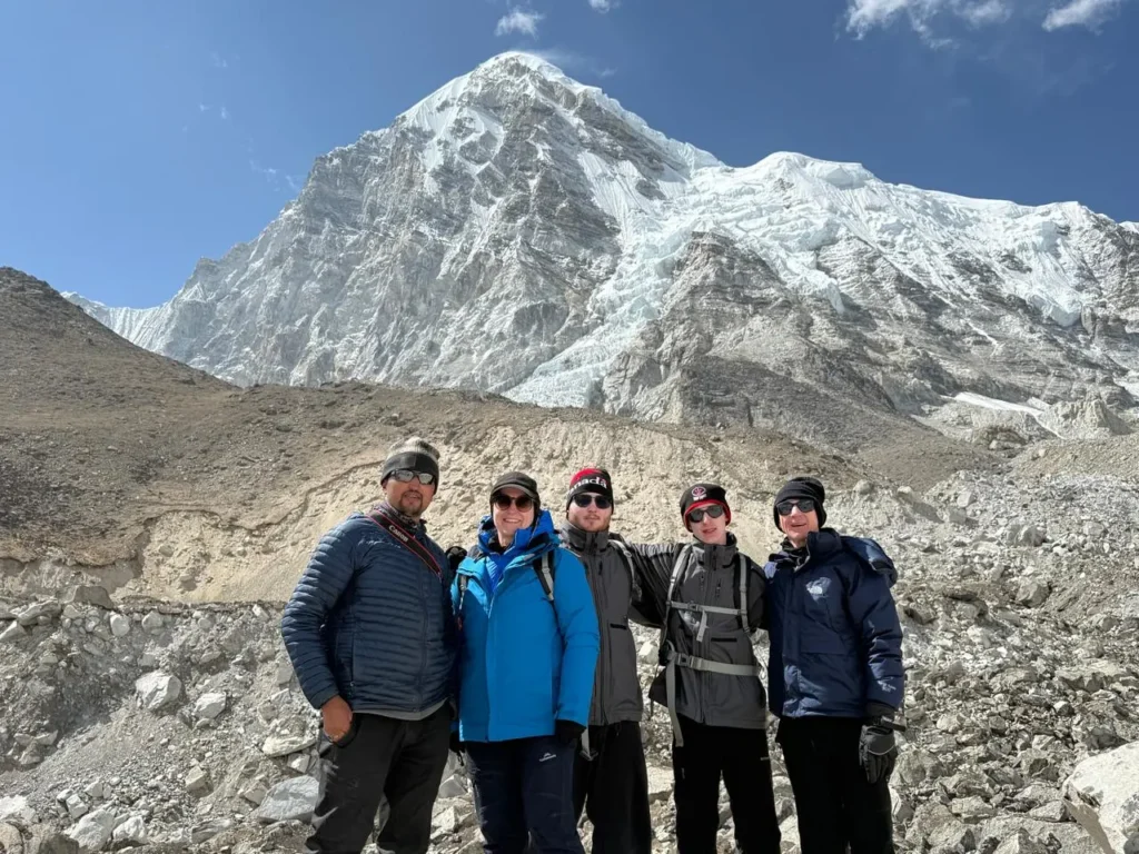 trekkers at Kala Patthar viewpoint overlooking Everest Base Camp and surrounding Himalayan peaks.