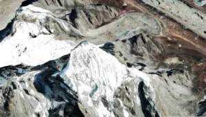 2D satellite view of Lobuche Peak showing snow-covered ridges and steep rocky slopes, with the nearby settlement of Lobuche visible in the rugged Himalayan landscape.