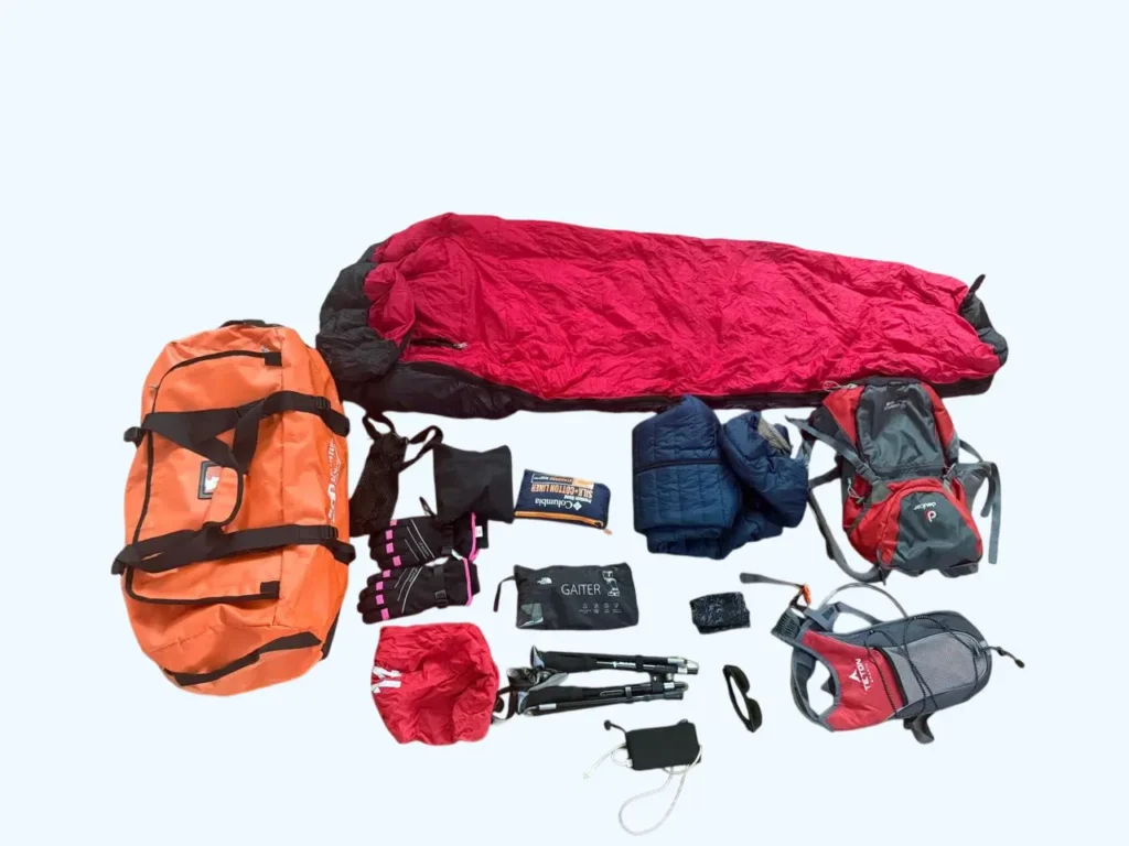 Trekking gear set with backpack, sleeping bag, jacket, gloves, trekking poles, and accessories.