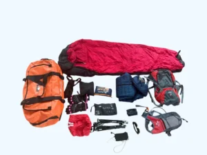 Trekking gear set with backpack, sleeping bag, jacket, gloves, trekking poles, and accessories.