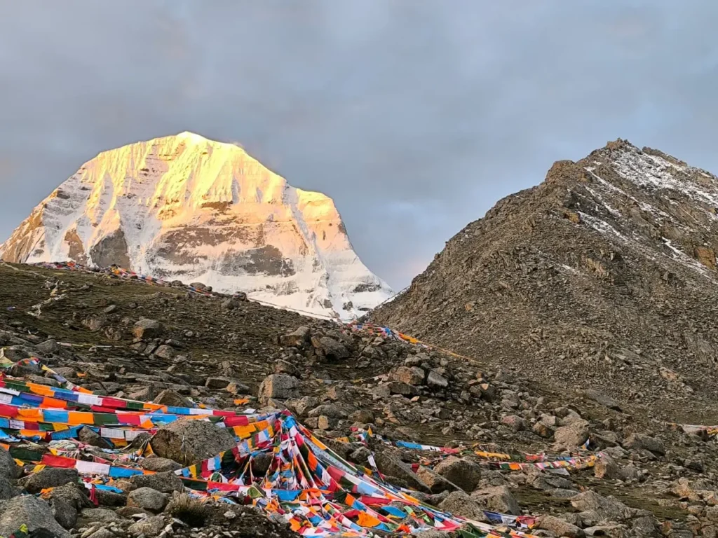 How to Get to Kailash Mansarovar Yatra: Complete Flight Guide for USA, UK, Canada & Europe 3 Mount Kailash glowing at sunrise with colorful prayer flags in the foreground