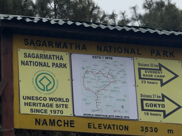 Signboard of Sagarmatha National Park at Namche Bazaar showing directions to Everest Base Camp and Gokyo with elevation details