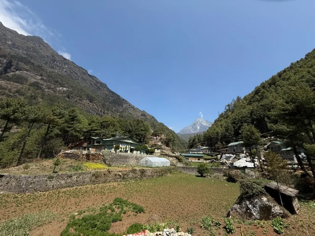 Sagarmatha National Park: A Complete Travel Guide to Nepal's Everest Region 6 Mountain village in Sagarmatha Region with terraced fields and forested hills.