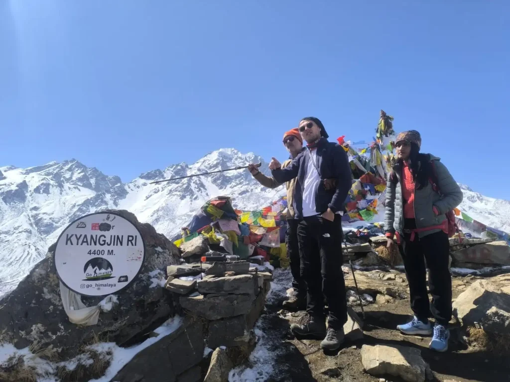 How to Trek Langtang Valley as a Beginner: Complete Step-by-Step Guide 3 Trekkers standing at the Kyangjin Ri (4,400 meters) viewpoint in Langtang Valley.